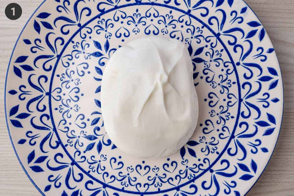 Piece of burrata left on a plate to come to room temperature