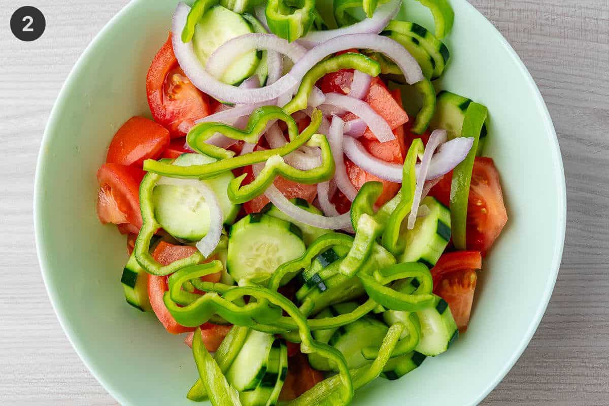 Greek Salad ingredients added to a salad bowl