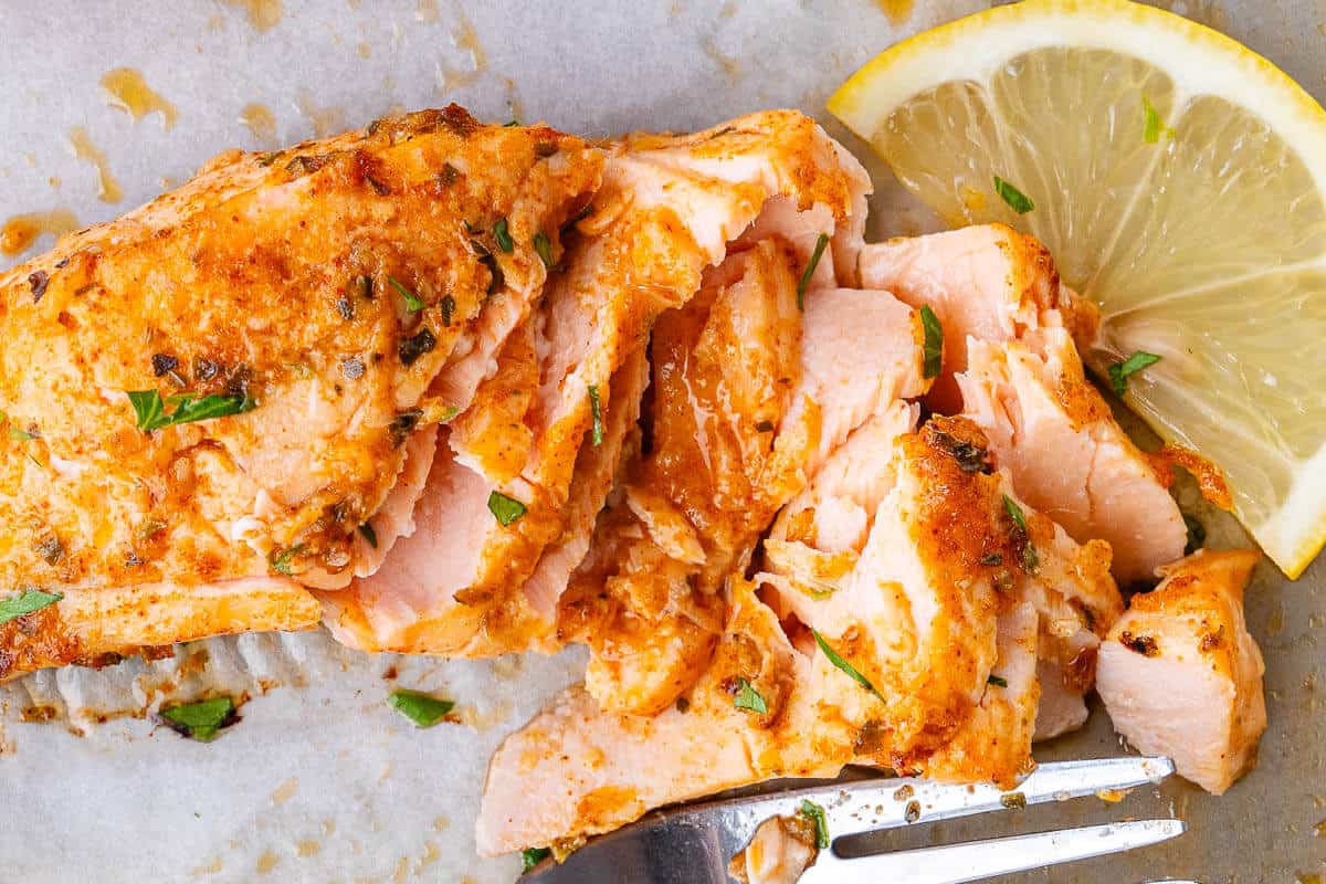 Lemon Garlic Salmon flaked with a fork to show the inside texture