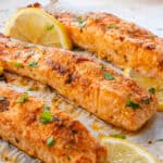 Lemon Garlic Salmon fillets on an oven tray, topped with parsley