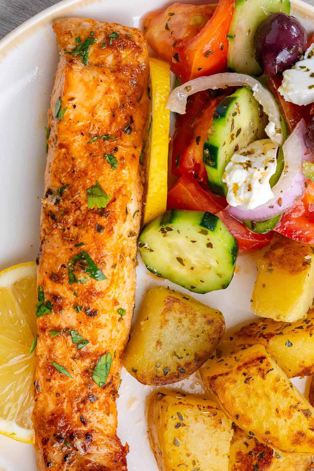 Piece of Lemon Garlic Salmon with Greek salad and roasted potatoes