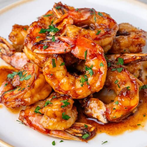 Honey garlic shrimp glazed with sauce and topped with chopped parsley