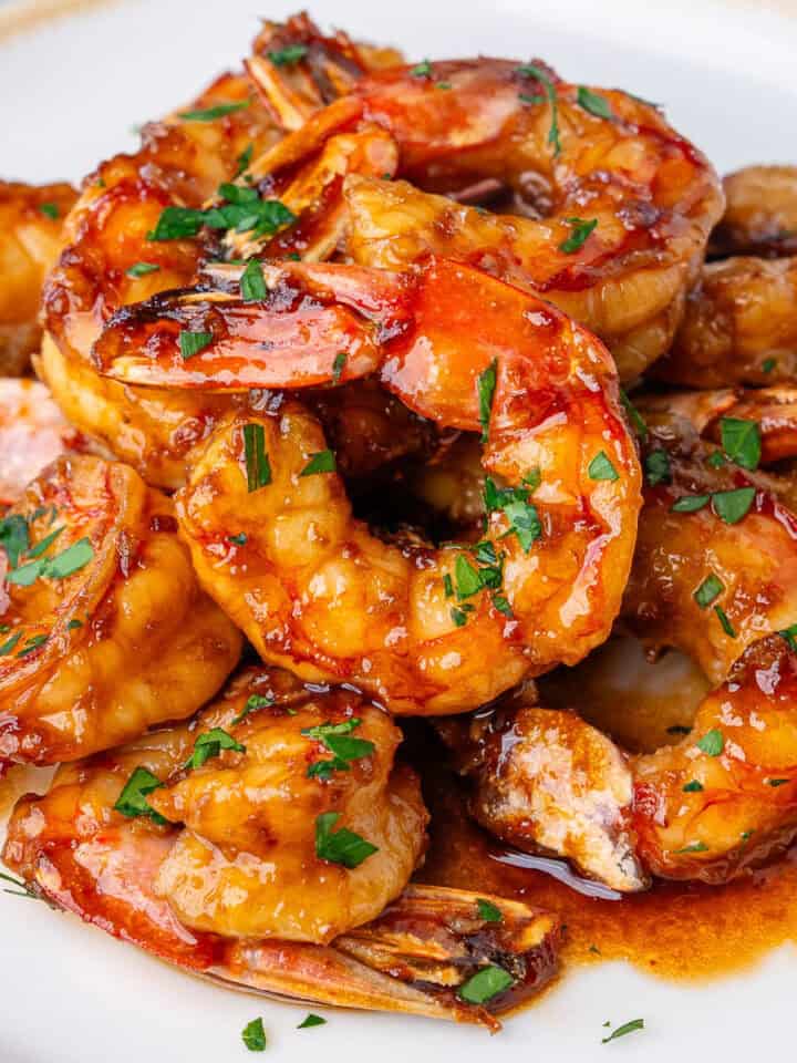Honey garlic shrimp glazed with sauce and topped with chopped parsley