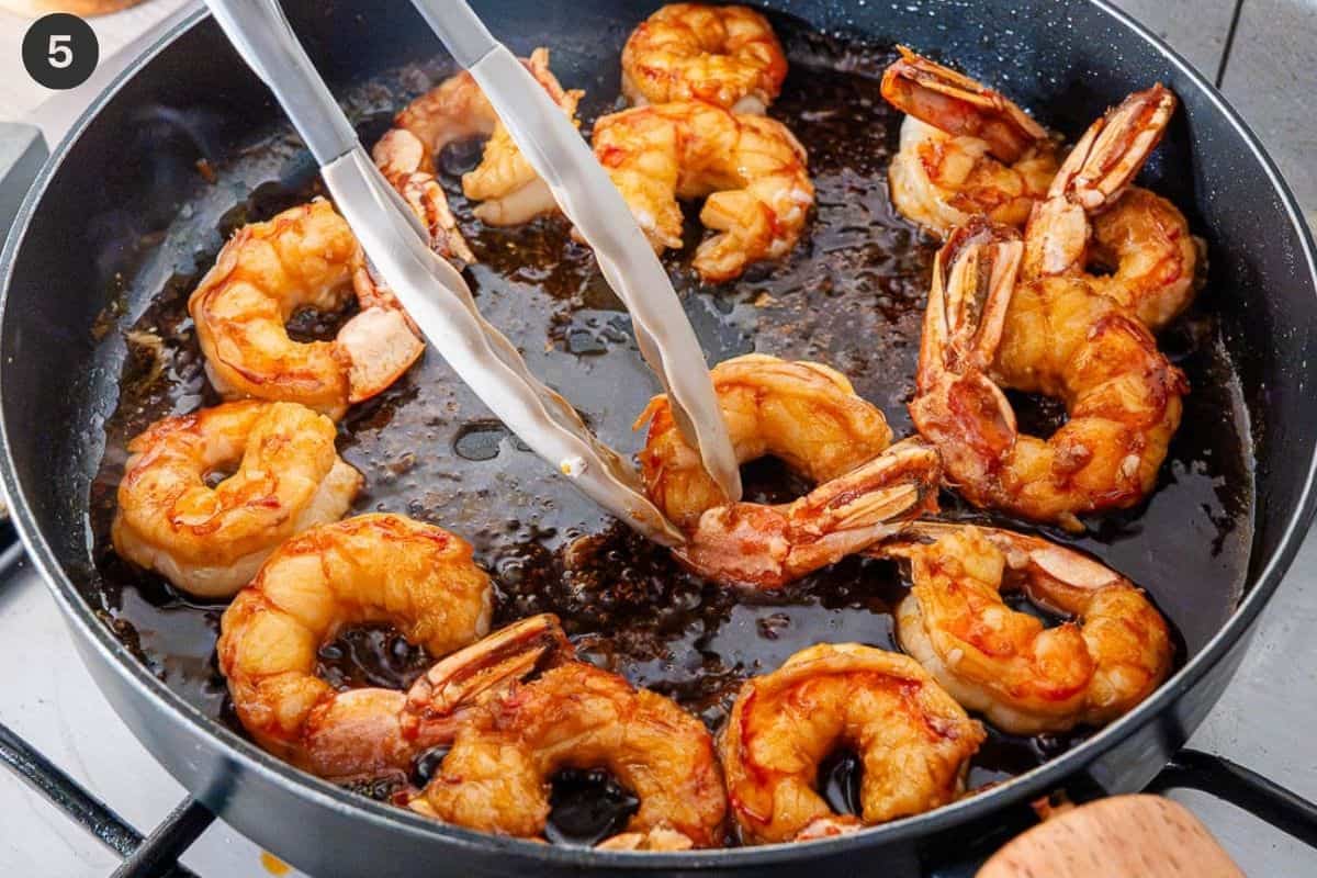Shrimp pieces being turned over in the sauce